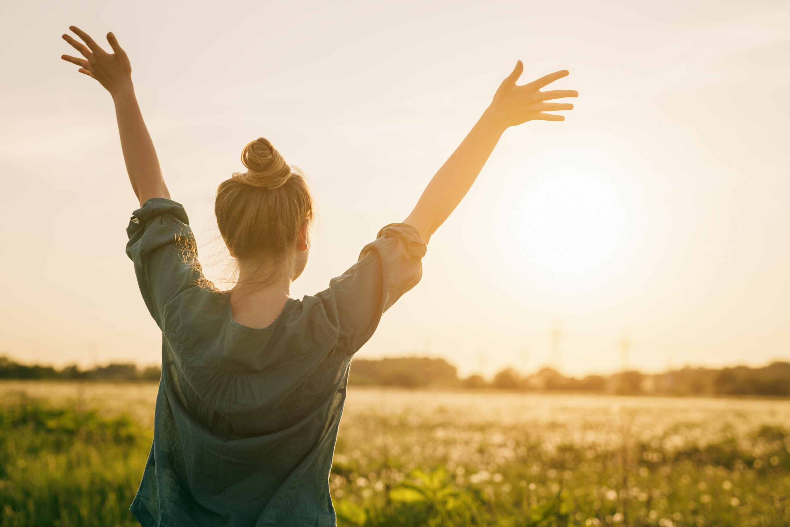 female teen girl stand feel freedom with arms stretched to the sky